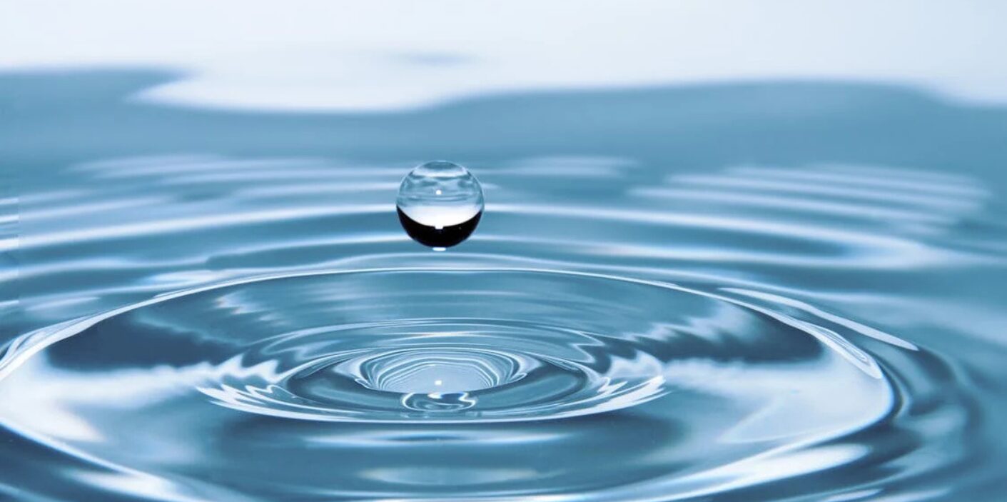 Water droplet on calm water surface - Eco-Friendly Plumbing Tips