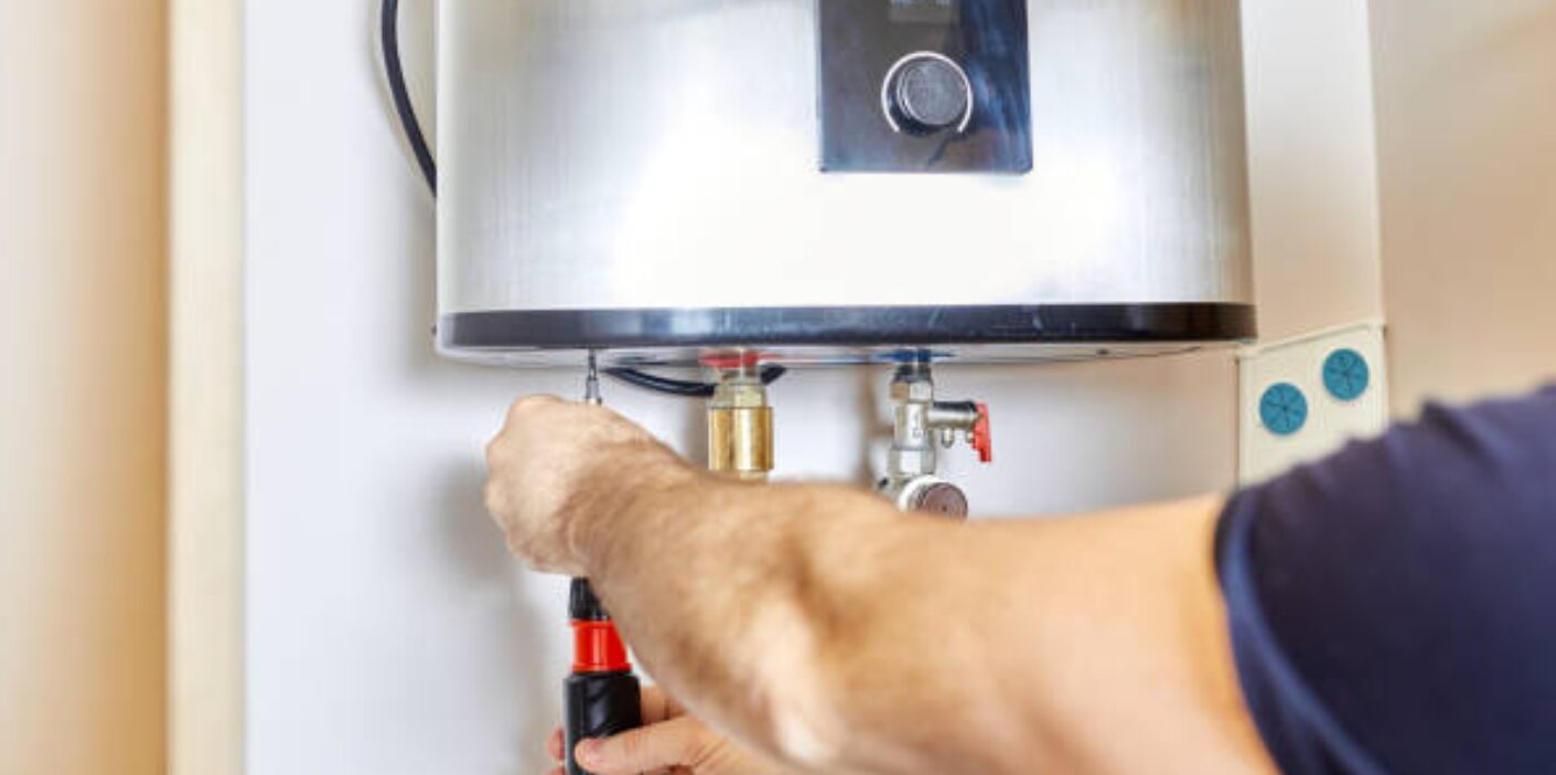 Plumber adjusting a water heater valve with a screwdriver – Water Heater Maintenance Tips