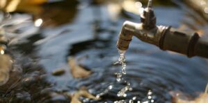 Outdoor faucet dripping water in autumn, highlighting the need for preventive maintenance in commercial plumbing this fall.