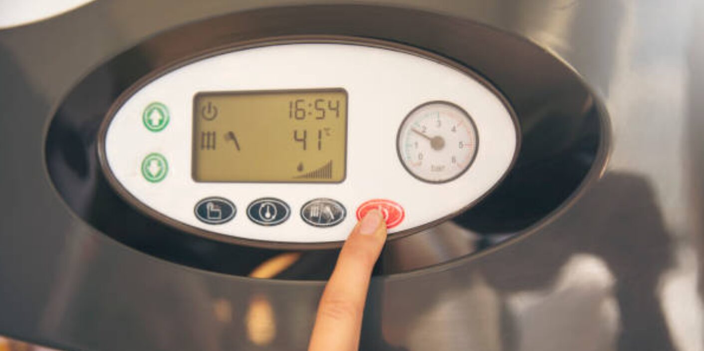 Hand adjusting the digital controls of a modern Tankless water heater, showing temperature and settings for efficient hot water.