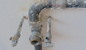 Corroded main water line pipes needing professional repair.