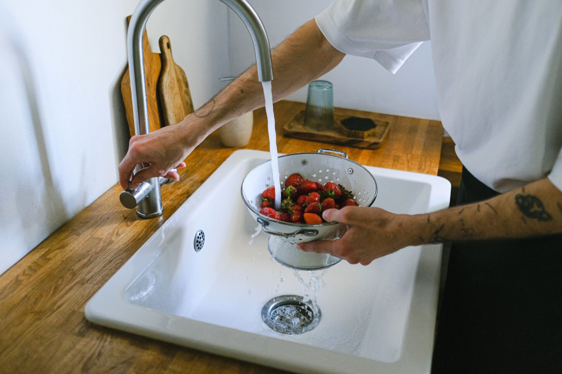 Homeowner rinsing food in a kitchen sink with a garbage disposal drain