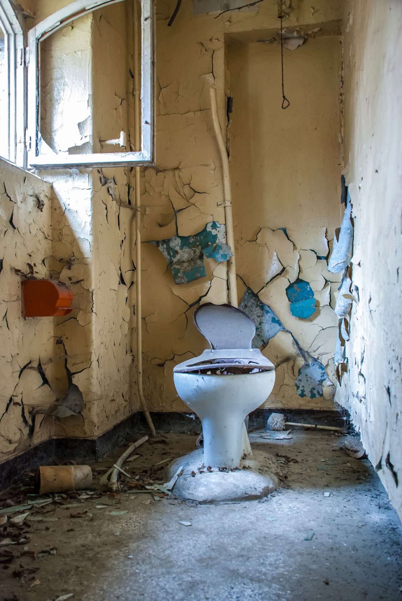 Old damaged toilet in a deteriorating bathroom showing signs you need a new toilet