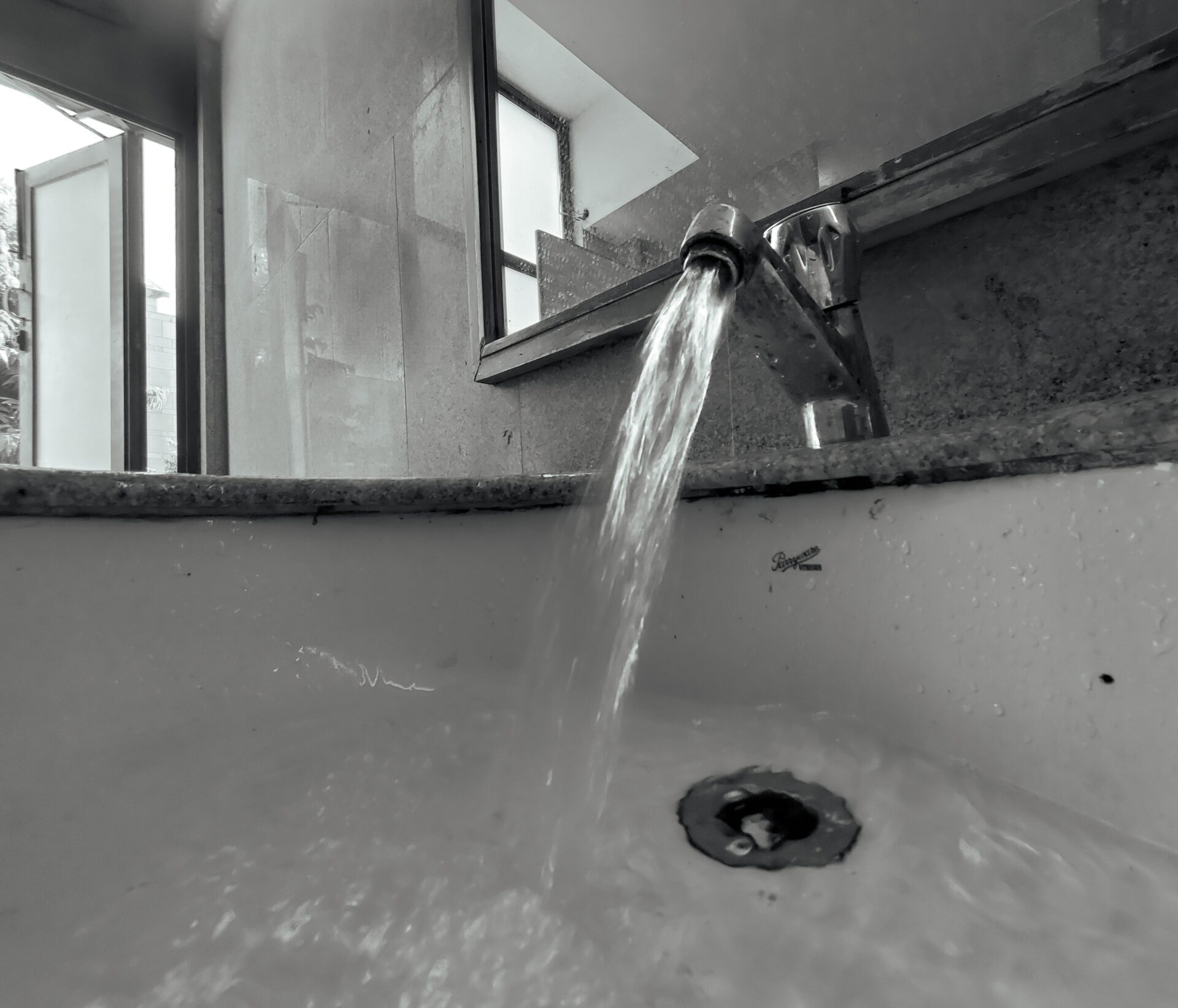 Water flowing from a faucet into a sink drain in a Knoxville Tennessee home with a slow drain